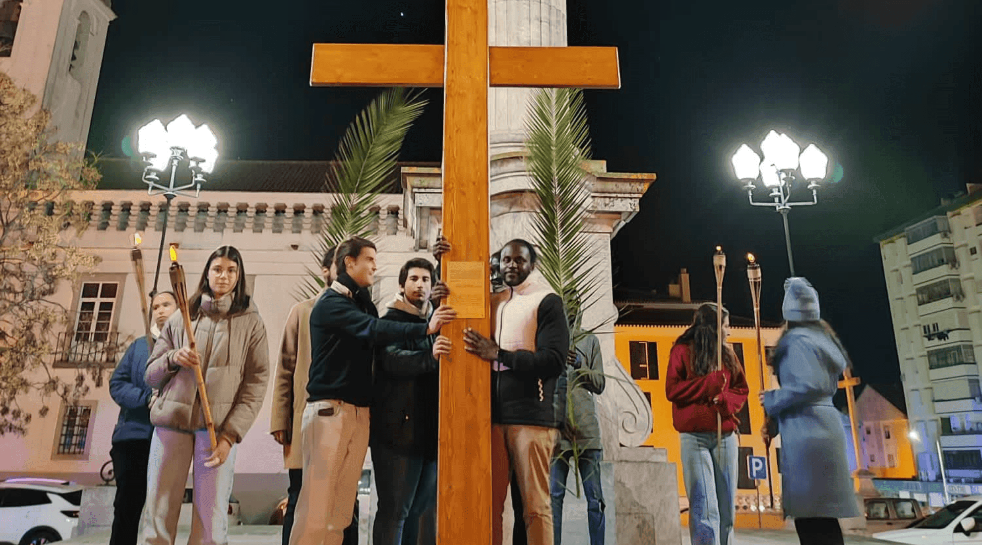 Jovens seguram réplica da Cruz da JMJ e tochas de luz ao seu lado