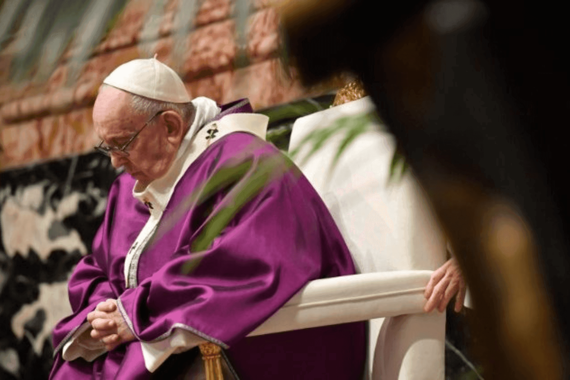 El Papa Francisco, con vestidura púrpura, mira hacia abajo en un momento de reflexión